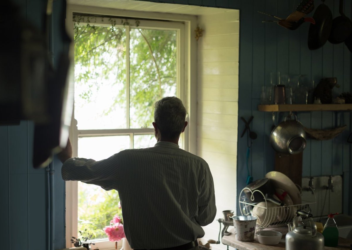 Mann schaut aus Fenster.jpg