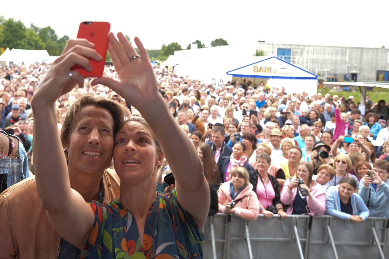 „Rote Rosen“ Fantag 2017: Hakim Michael Meziani und Jelena Mitschke machen Selfies auf der Bühne mit Fans im Hintergrund.