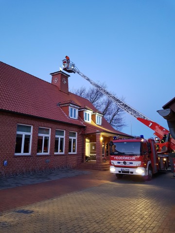 Die Feuerwehr demontiert die Wetterfahne.