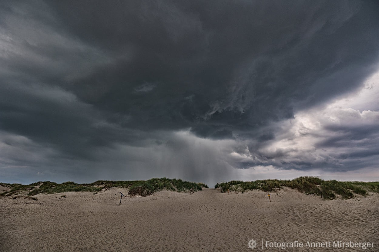 Düstere Wolken ziehen über Sankt Peter-Ording und die Nordsee hinweg.