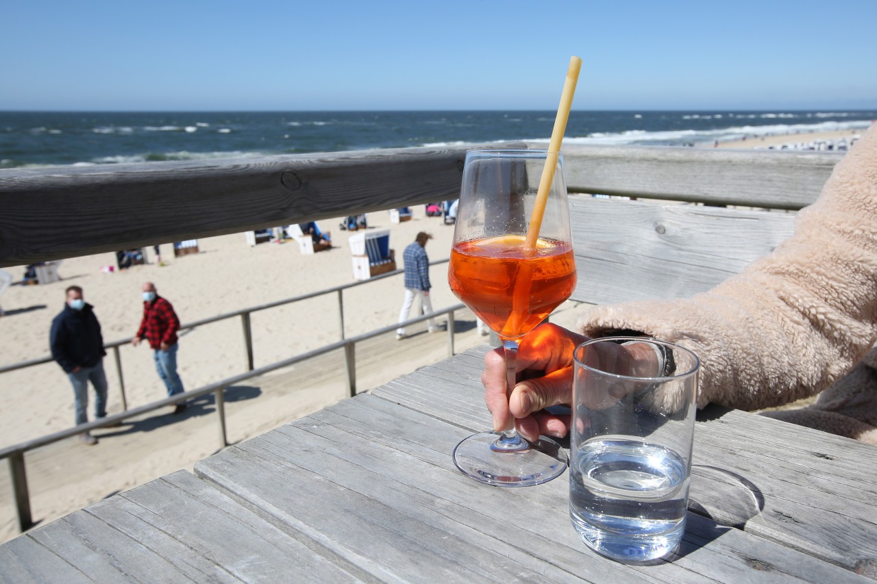 Eine Frau genießt das sonnige Wetter am Strand auf Sylt.