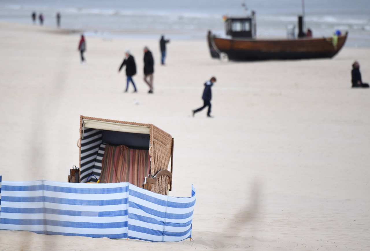 Spaziergänger sind am Ostersonntag an einem Strand auf der Insel Usedom unterwegs.