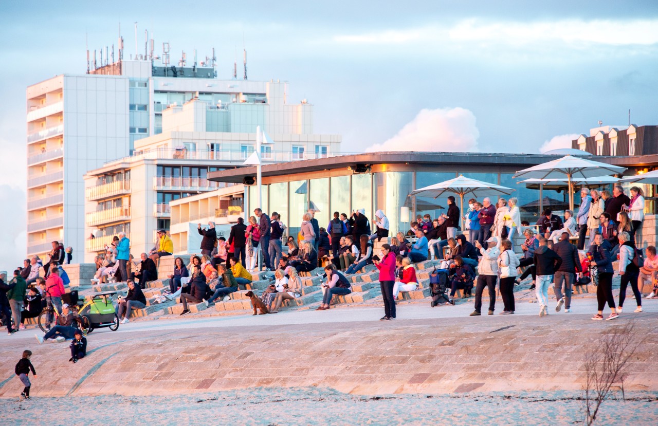 Urlaubsgäste betrachten an der Milchbar am Nordstrand von Norderney den Sonnenuntergang.