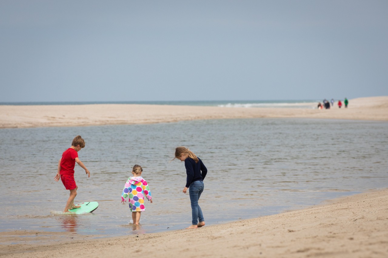 Kinder spielen am Strand von Sylt. 