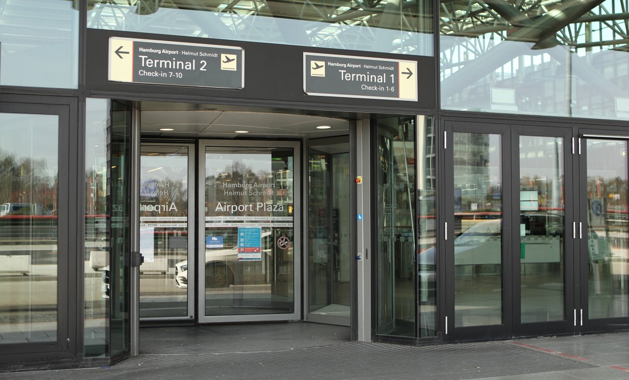 Flugreisende stehen vor den Check-In-Schaltern am Flughafen Hamburg. 