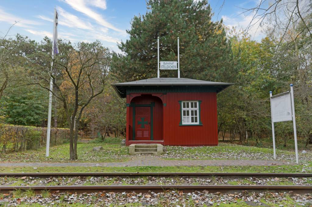 Altes Bahnhofshaus mit Gleisen.